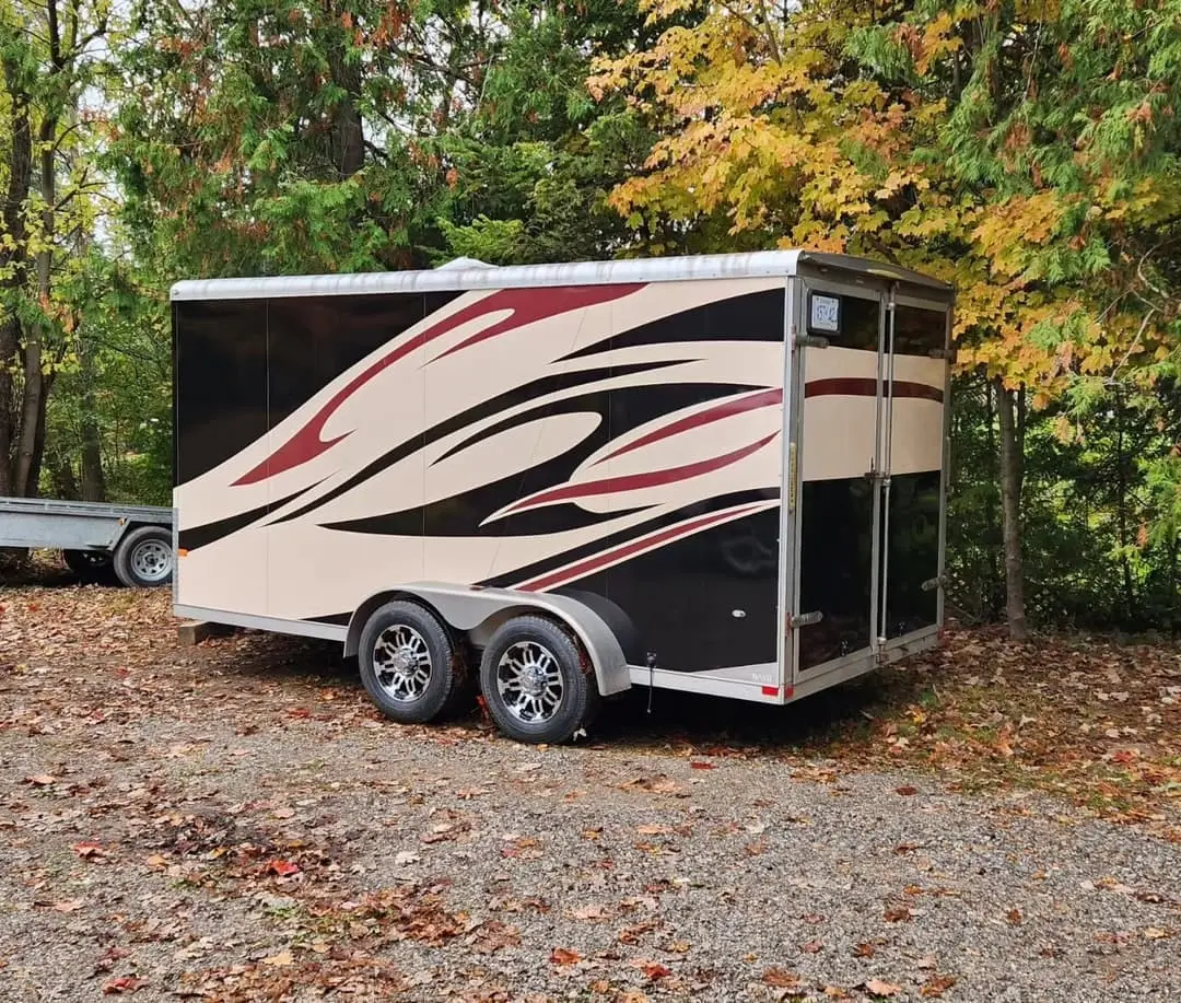 Enclosed cargo trailer with red and black stripe graphics
