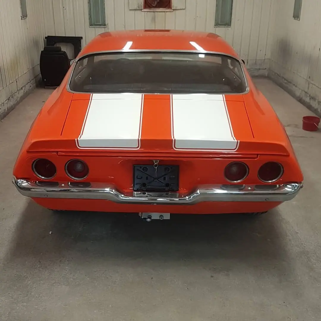 Orange classic Camaro with white stripes
