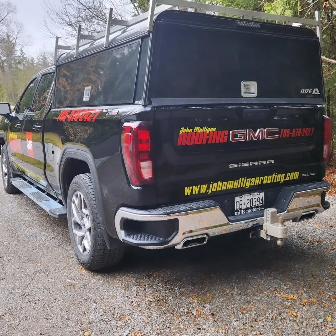 Black GMC pickup with door and tailgate lettering