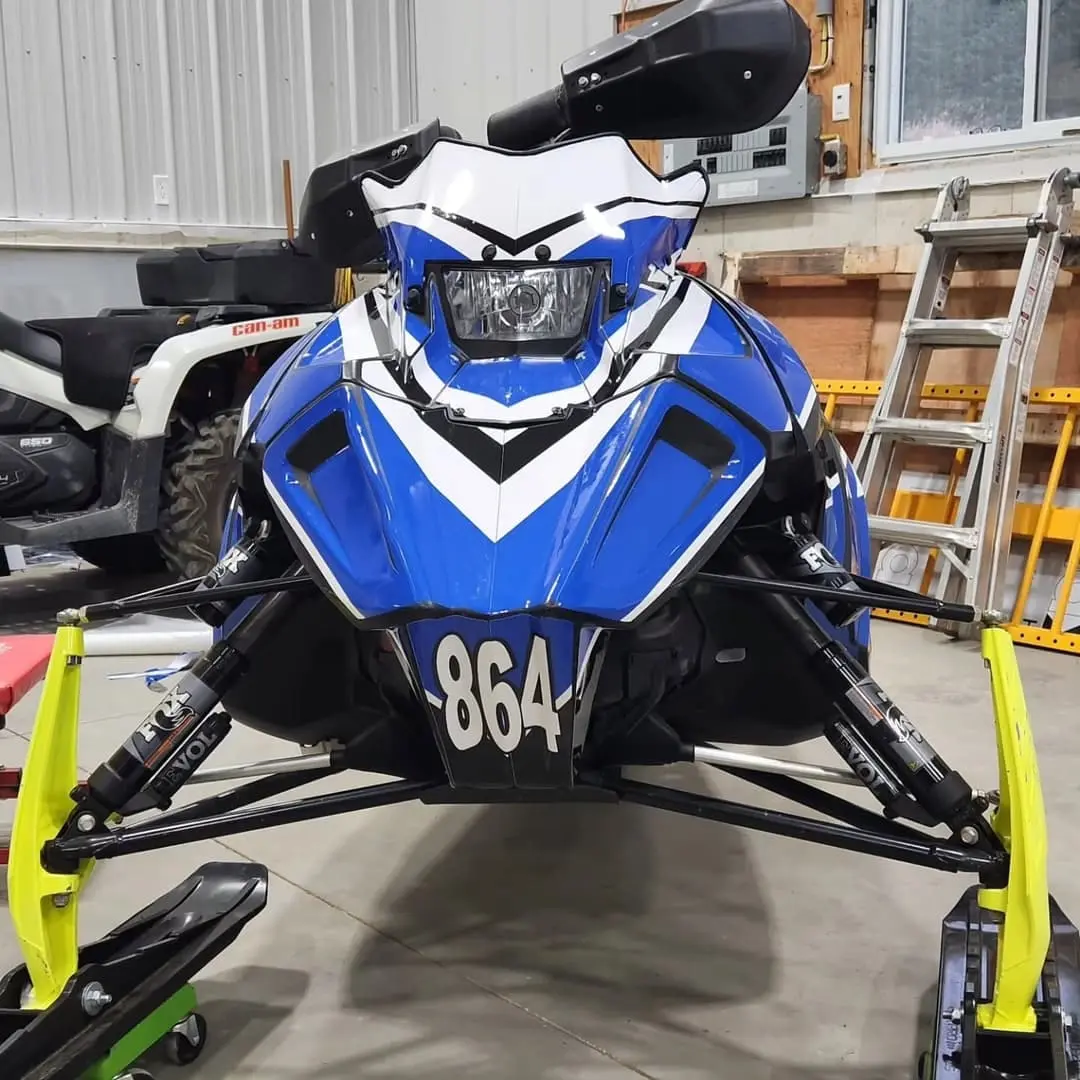 Snowmobile in a blue and yellow custom wrap