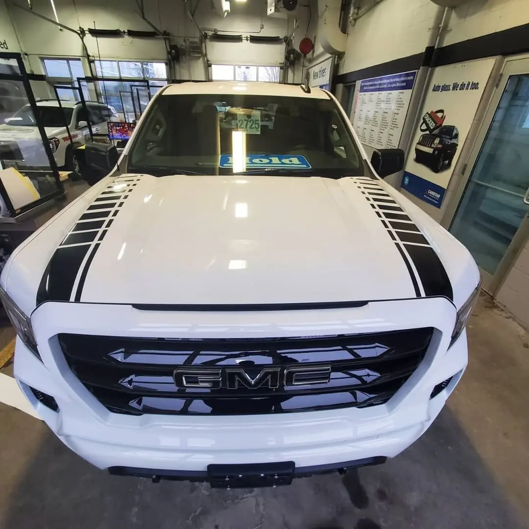 White pickup with black hood graphics