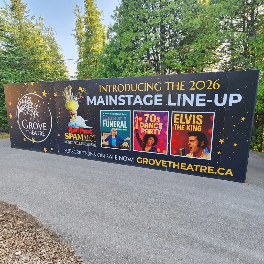 Grove Theatre stage backdrop with a lit steering-wheel sign