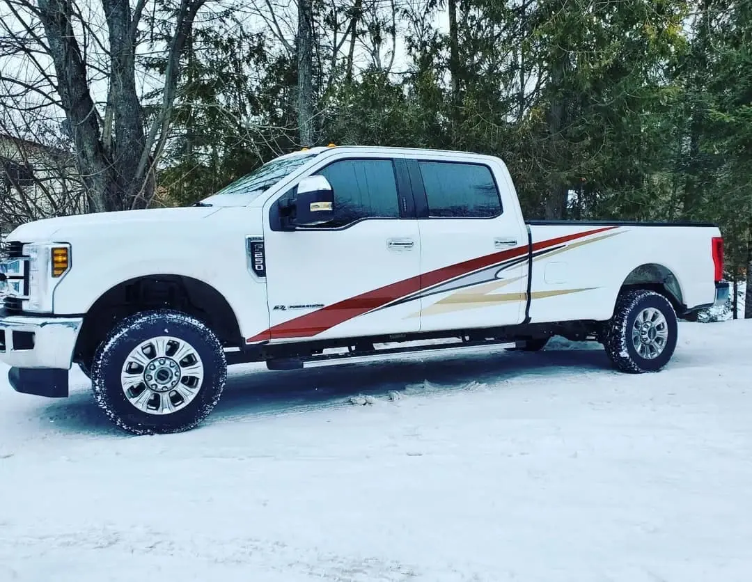 White Ford Super Duty with stripes matched to a camper