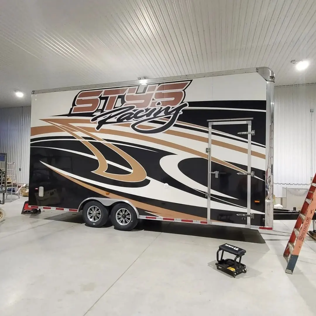 Toy hauler trailer wrapped in black and gold graphics